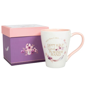 Tasse "Gott hält Dich in seiner Hand" mit Kranz aus Federn und Blüten im Boho-Stil